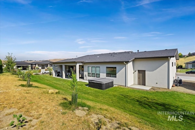 1889 W Winter Camp Ct, Boise, ID 83703 - back of property featuring a hot tub, stucco siding, a lawn, and a patio area