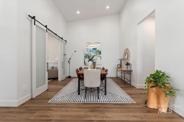 1889 W Winter Camp Ct, Boise, ID 83703 - dining space featuring a barn door, a towering ceiling, wood finished floors, recessed lighting, and baseboards