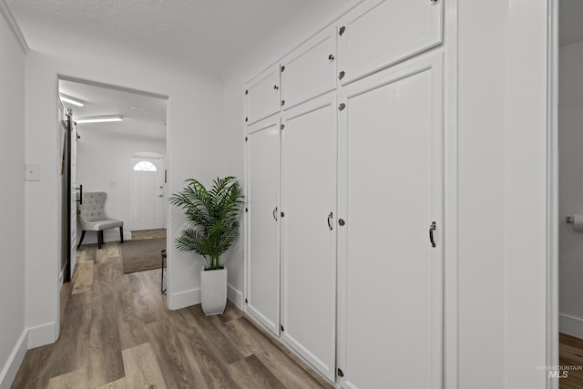 hall with baseboards and wood finished floors