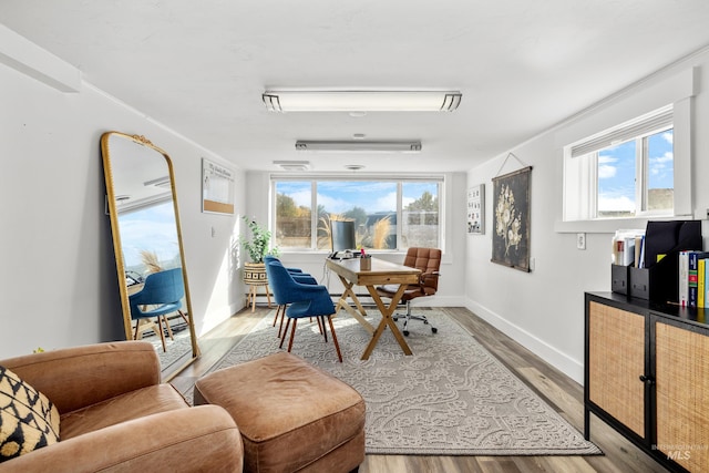 sitting room with light wood-style flooring, a wealth of natural light, and baseboards