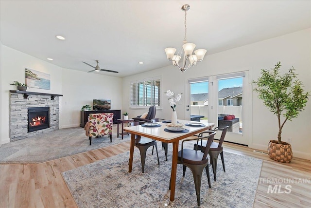 12740 S Alzano Way, Nampa, ID 83686 - dining room featuring light wood-style floors, a chandelier, a stone fireplace, baseboards, and recessed lighting