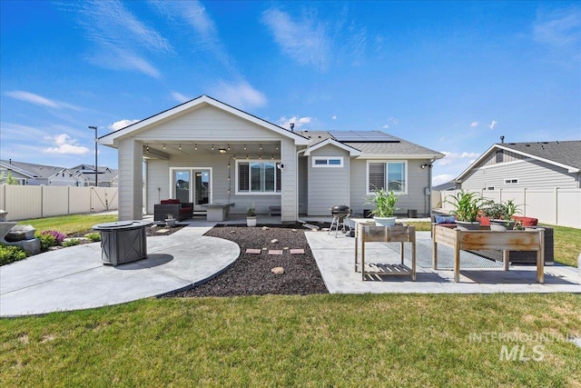 12740 S Alzano Way, Nampa, ID 83686 - rear view of house with a patio area, roof mounted solar panels, and an outdoor living space with a fire pit