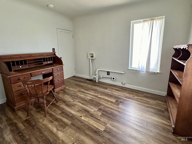 office area with dark wood-style floors, a textured ceiling, and baseboards