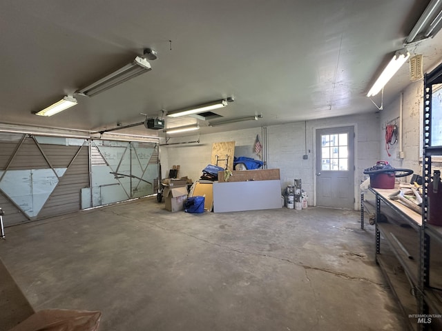 garage with concrete block wall and a garage door opener