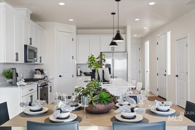 dining space with recessed lighting, visible vents, and light wood finished floors