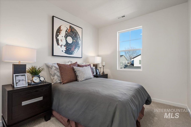 carpeted bedroom featuring baseboards and visible vents