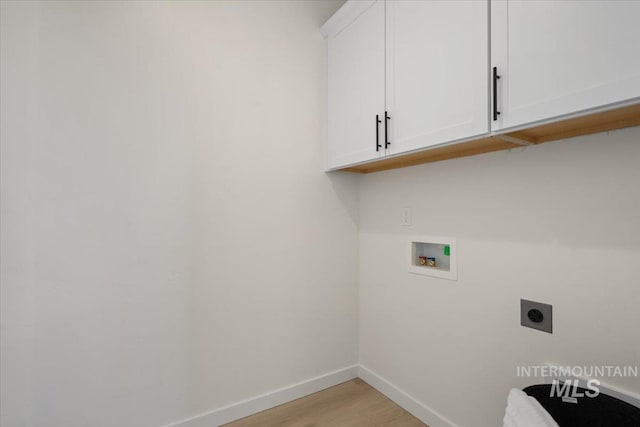 washroom featuring baseboards, hookup for a washing machine, light wood-style floors, cabinet space, and electric dryer hookup