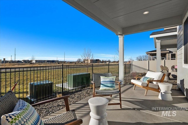 view of patio / terrace featuring central air condition unit and fence