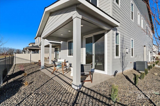 rear view of property featuring a patio area, central AC unit, and a fenced backyard