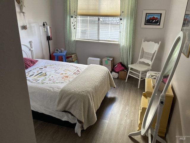 bedroom with dark hardwood / wood-style floors