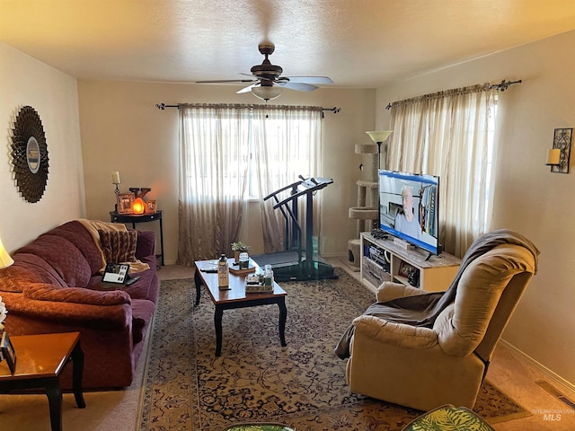 living room featuring ceiling fan and a textured ceiling