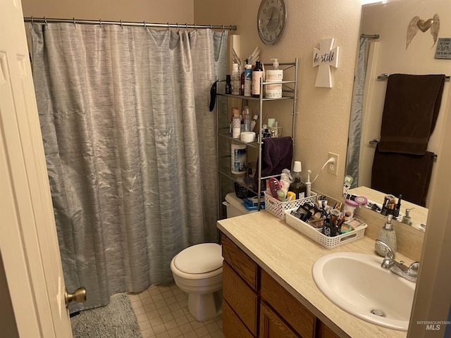 bathroom with a shower with curtain, vanity, toilet, and tile patterned flooring