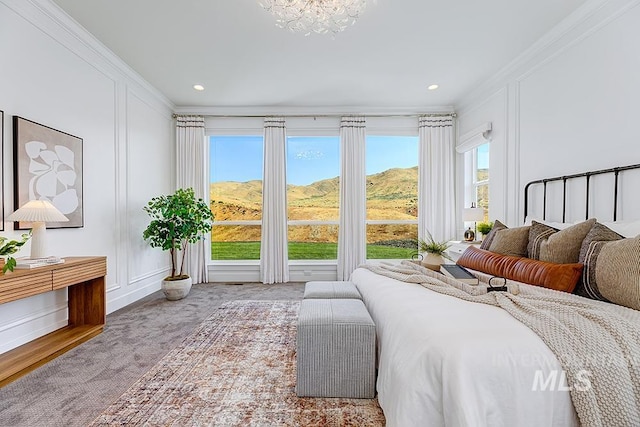 carpeted bedroom featuring an inviting chandelier, multiple windows, and ornamental molding