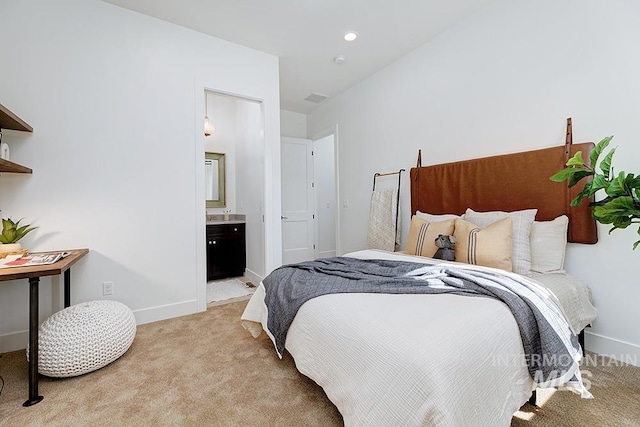 bedroom with light carpet and connected bathroom