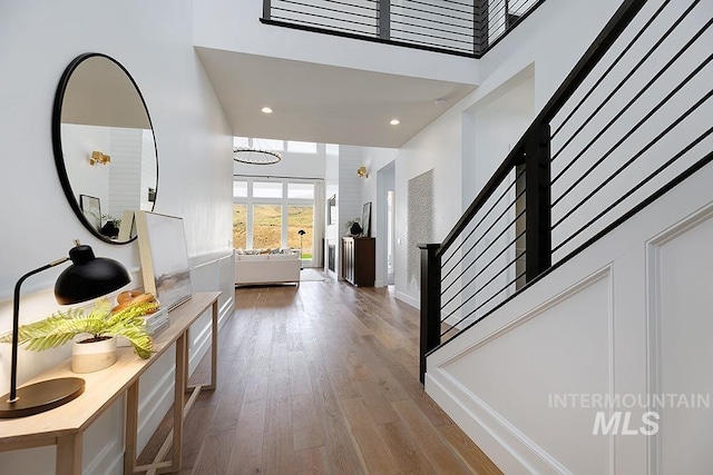 foyer entrance featuring hardwood / wood-style floors and a high ceiling