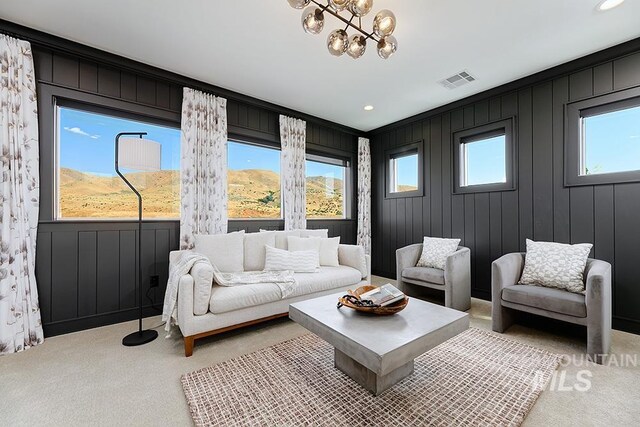 living room featuring light carpet, an inviting chandelier, and a healthy amount of sunlight