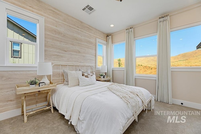 carpeted bedroom with wood walls