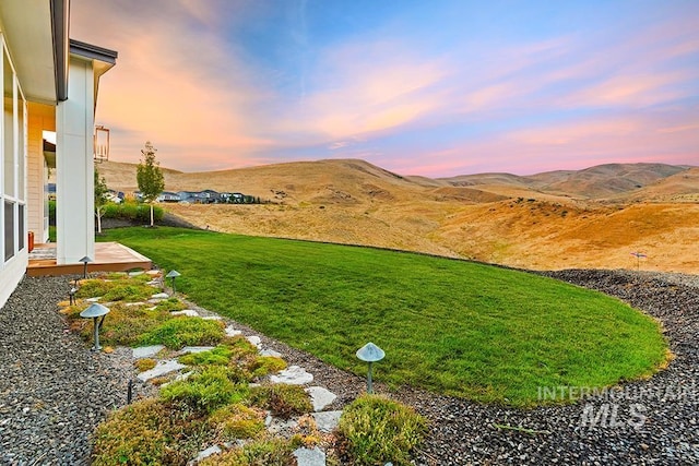 yard at dusk featuring a mountain view