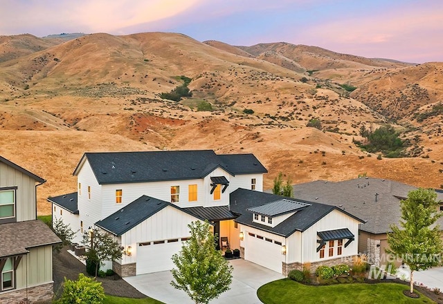 aerial view at dusk featuring a mountain view