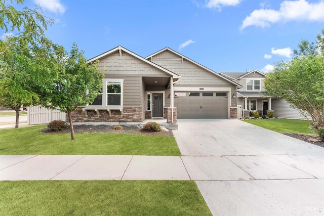 12457 W Awbrey St, Boise, ID 83709 - craftsman house featuring an attached garage, stone siding, a front yard, and concrete driveway