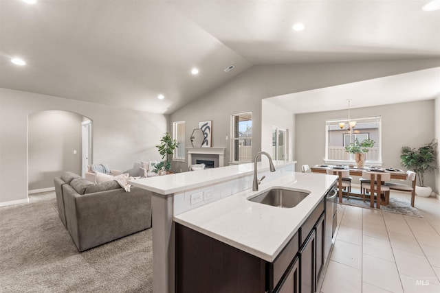 12457 W Awbrey St, Boise, ID 83709 - kitchen featuring open floor plan, arched walkways, a fireplace, vaulted ceiling, and a center island with sink