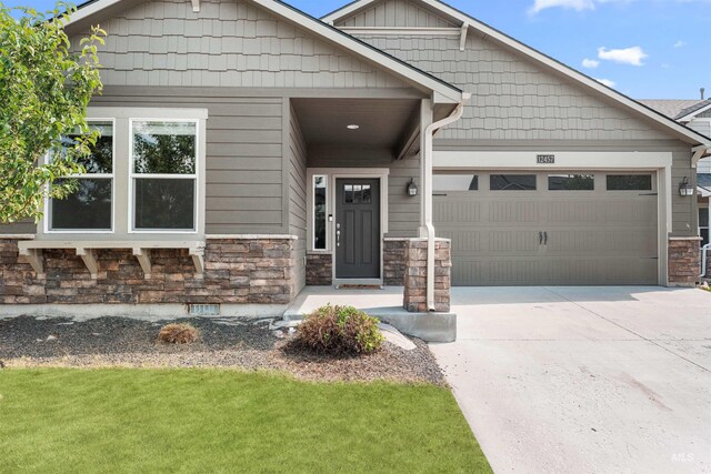 12457 W Awbrey St, Boise, ID 83709 - craftsman house featuring stone siding, a garage, and concrete driveway