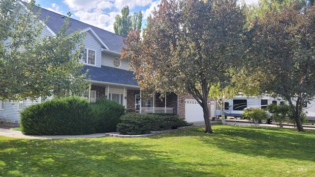 obstructed view of property with a garage and a front lawn