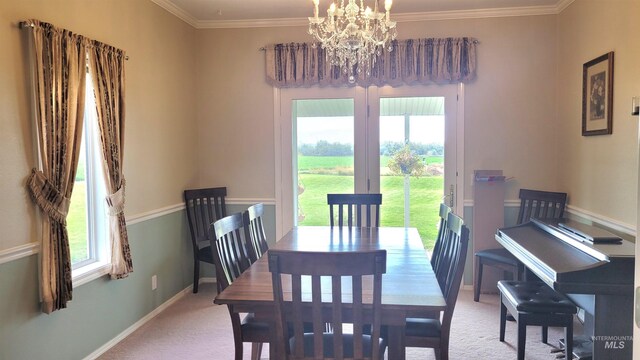 dining room featuring carpet floors, crown molding, and a notable chandelier