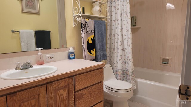 full bathroom with shower / tub combo, backsplash, vanity, and toilet