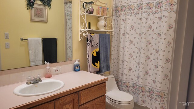 bathroom with a shower with curtain, vanity, and toilet