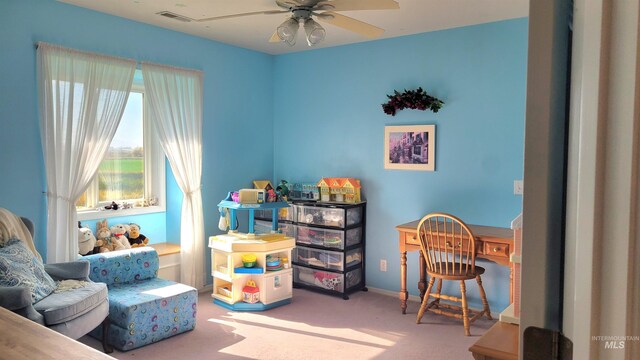 playroom featuring built in desk, carpet, and ceiling fan