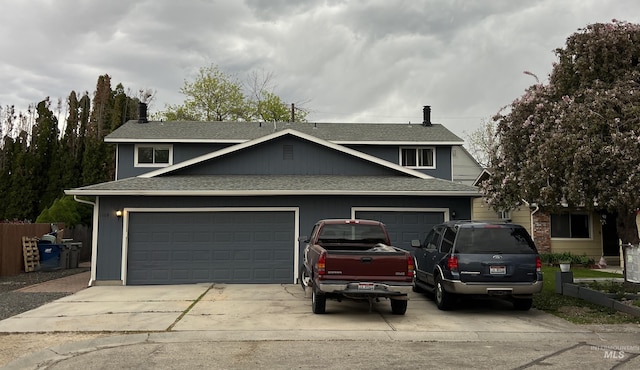 view of front facade featuring roof with shingles, an attached garage, and driveway