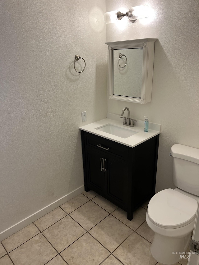 bathroom featuring tile patterned floors, toilet, baseboards, and vanity