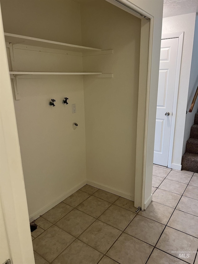 washroom featuring washer hookup, baseboards, and light tile patterned floors