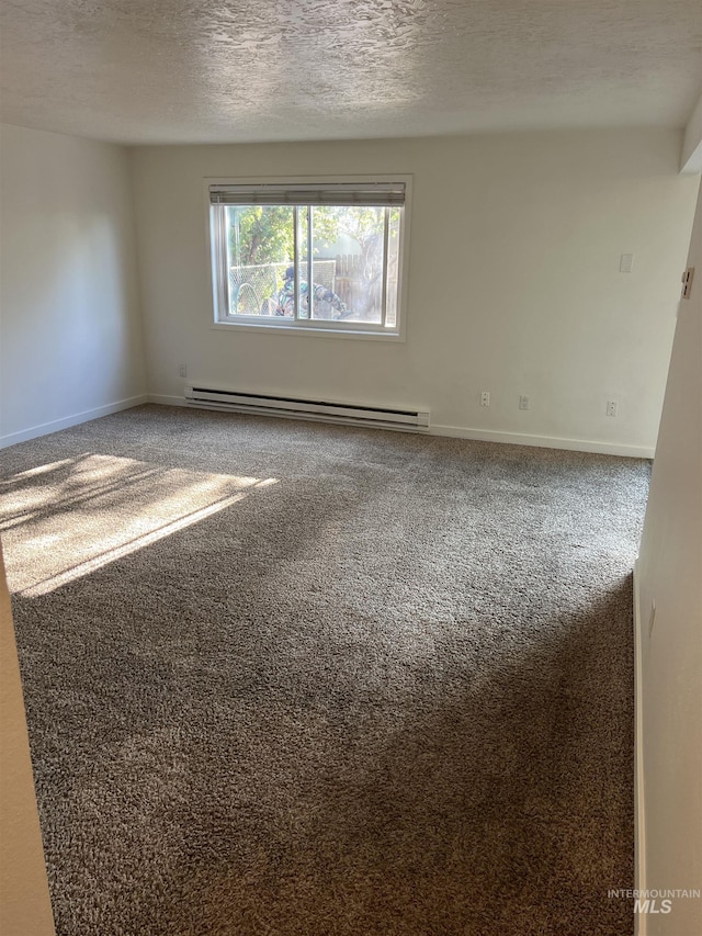 spare room with baseboards, carpet flooring, baseboard heating, and a textured ceiling