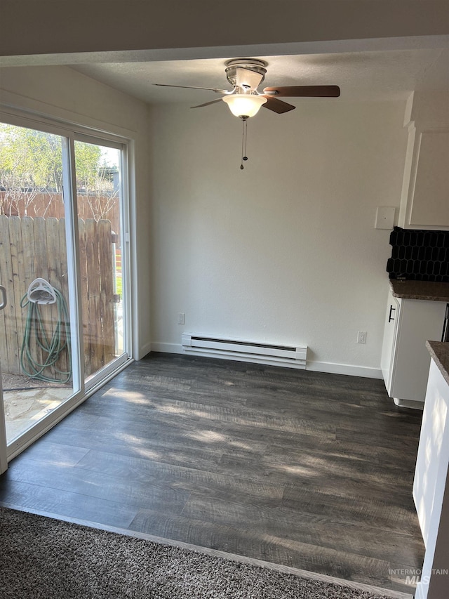 unfurnished dining area featuring a baseboard radiator, baseboards, ceiling fan, and dark wood-type flooring