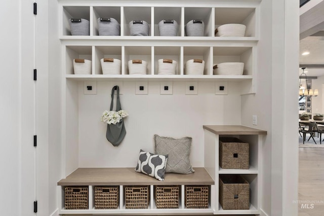 mudroom with a notable chandelier and hardwood / wood-style floors