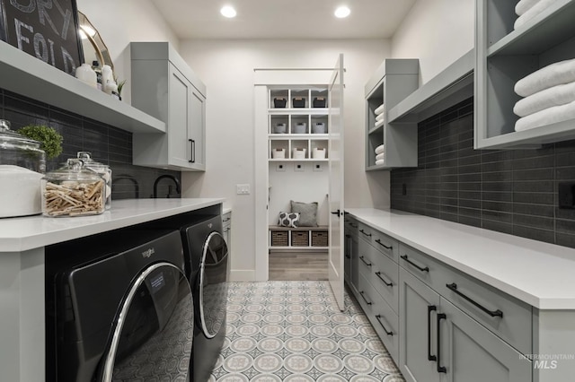 washroom featuring washer and clothes dryer, light tile patterned floors, and cabinets