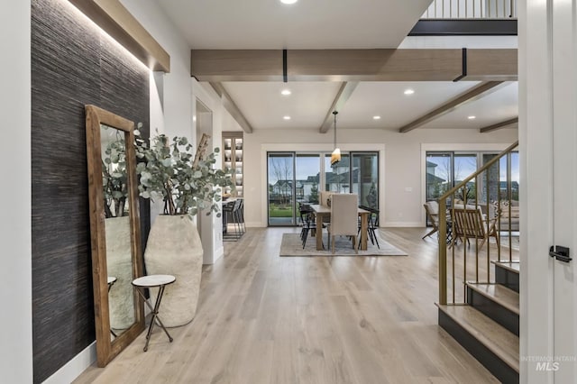 dining space featuring light wood-type flooring, plenty of natural light, and beamed ceiling