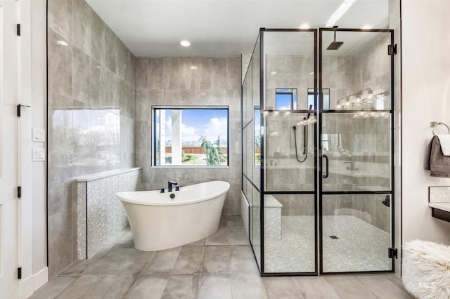 bathroom with tile walls and independent shower and bath