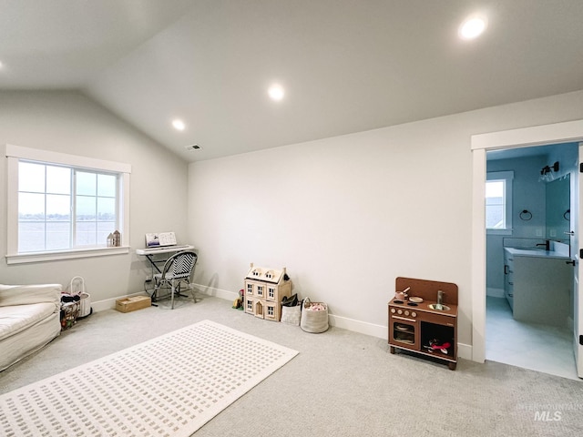 sitting room featuring carpet and vaulted ceiling