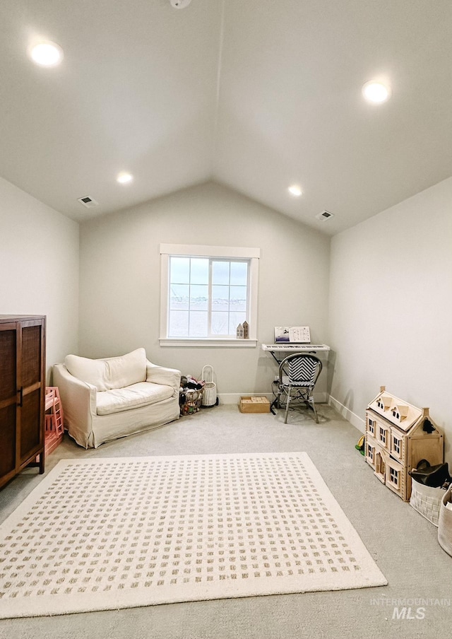 living area featuring carpet flooring and lofted ceiling