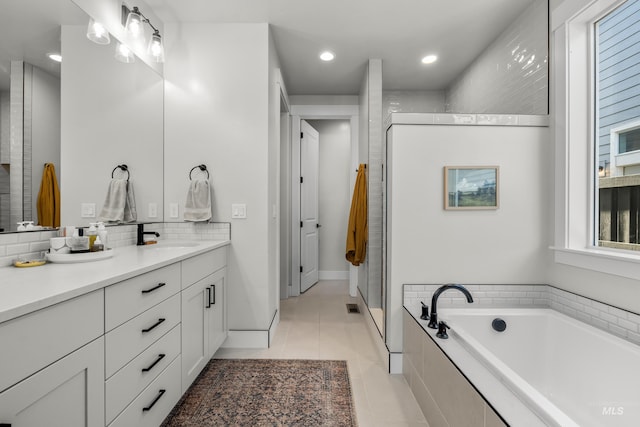 bathroom featuring plus walk in shower, tile patterned flooring, and vanity