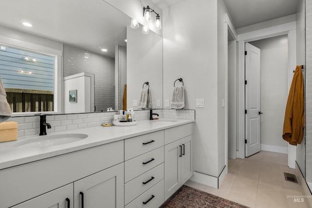 bathroom with tile patterned flooring, vanity, and decorative backsplash