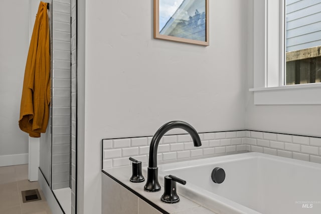 bathroom featuring a tub, plenty of natural light, tile patterned flooring, and sink