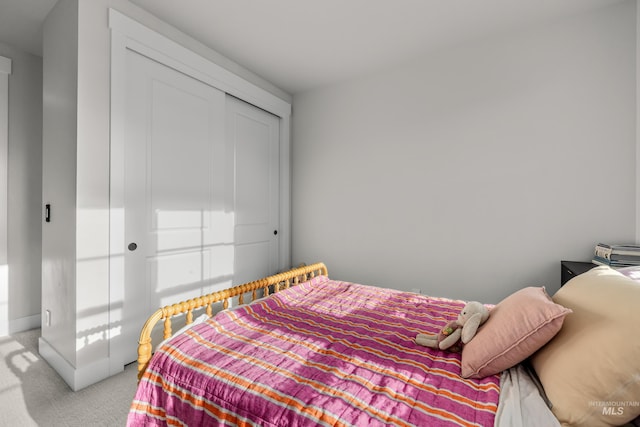 bedroom featuring a closet and light colored carpet