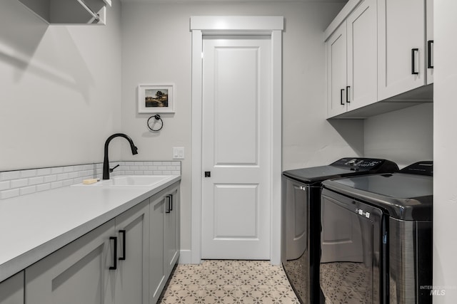 laundry area with washer and dryer, cabinets, and sink