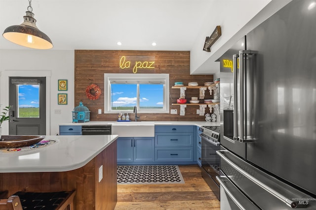 1400 Texas Ridge Rd, Deary, ID 83823 - kitchen featuring a sink, light countertops, wood finished floors, stainless steel appliances, and blue cabinets