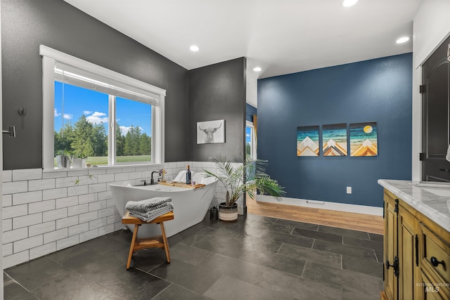 1400 Texas Ridge Rd, Deary, ID 83823 - bathroom featuring tile walls, a freestanding tub, vanity, and recessed lighting