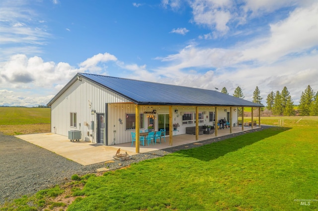 1400 Texas Ridge Rd, Deary, ID 83823 - rear view of house with board and batten siding, central AC, a lawn, metal roof, and a patio area